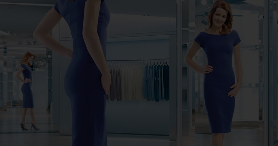 Woman wearing blue dress looking at herself in mirror