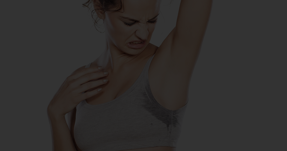 Woman looking at her sweaty armpit.